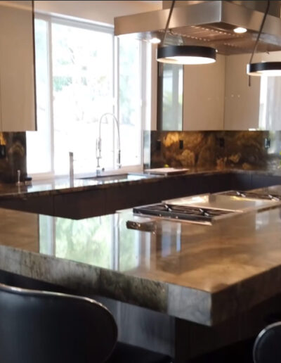Granite island style kitchen with lighting fixtures and bar stools